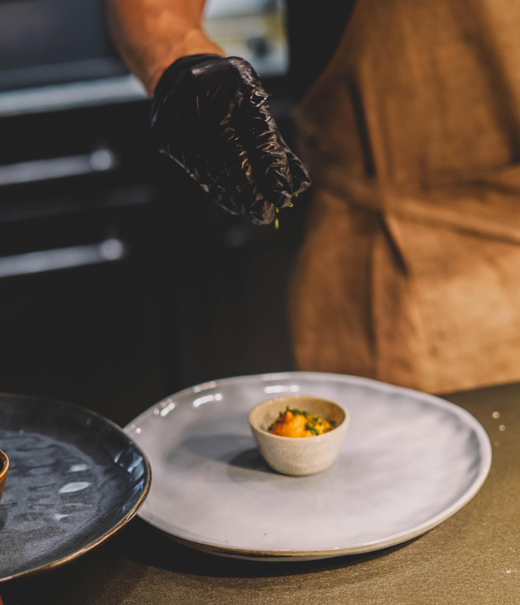 Chef arranging plate in studio kitchen